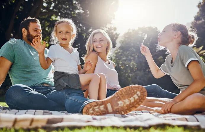 happy family playing outside on picnic blanket in virginia